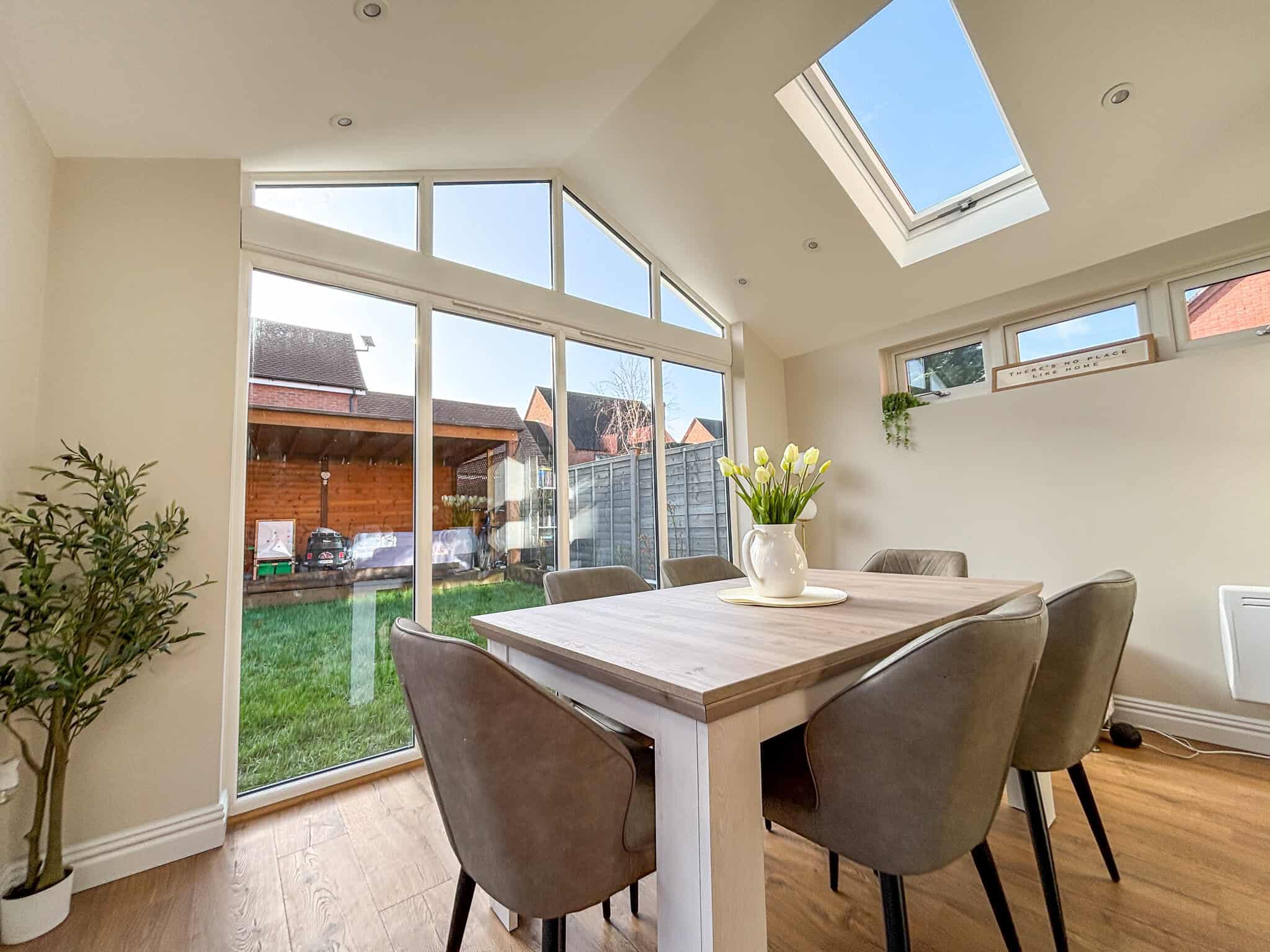 Interior of the modular extension showing the dining area, vaulted ceiling and full-height glazing